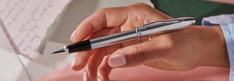  Woman holding the Townsend Lustrous Chrome Rollerball Pen with polished chrome appointments.