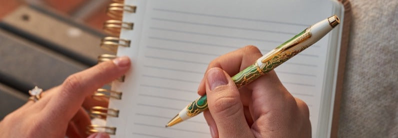 Woman holding the Wanderlust Borneo Ballpoint Pen, featuring a vibrant, nature-inspired design.